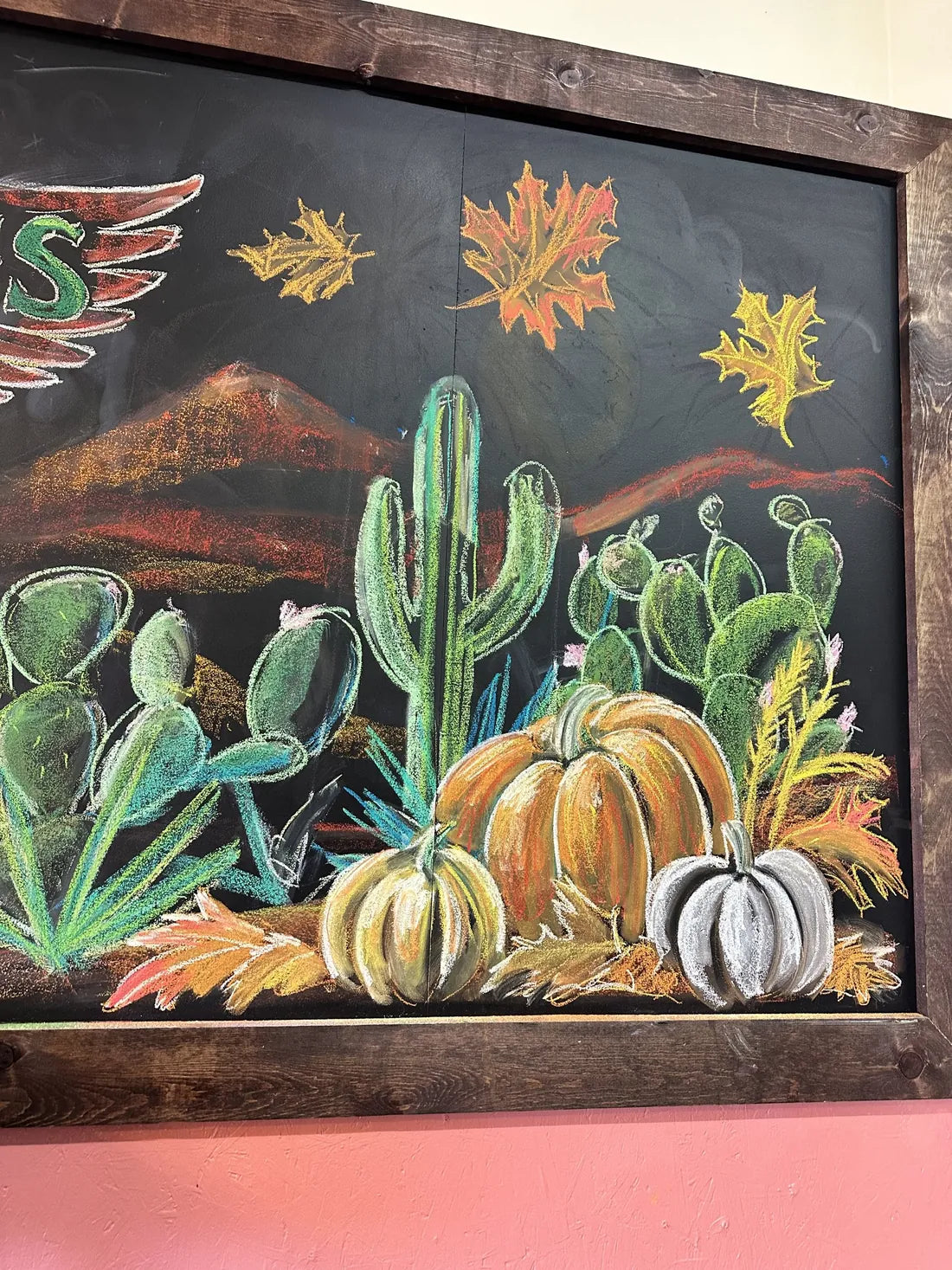 A fall chalk board with cactus and pumpkins
