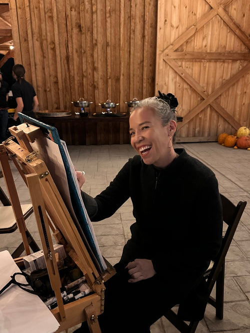 Susan Gromala painting live at an easel during an event